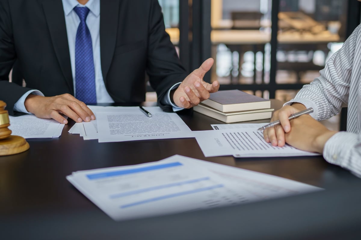 Legal counsel presenting a signed contract to a client